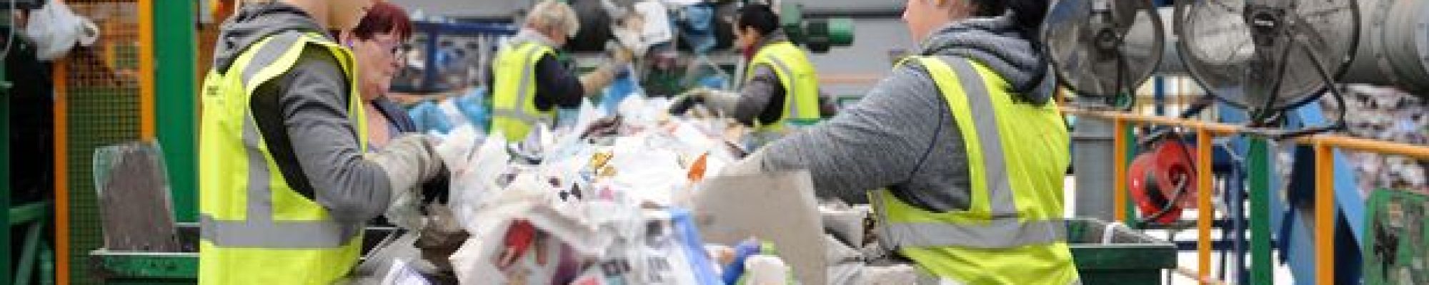 Workers in hi-vis sorting recycling on a conveyor