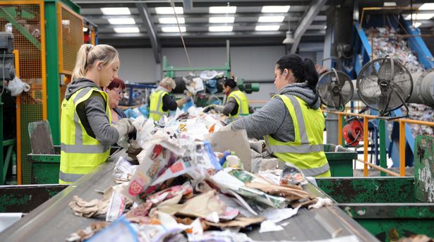 Workers in hi-vis sorting recycling on a conveyor