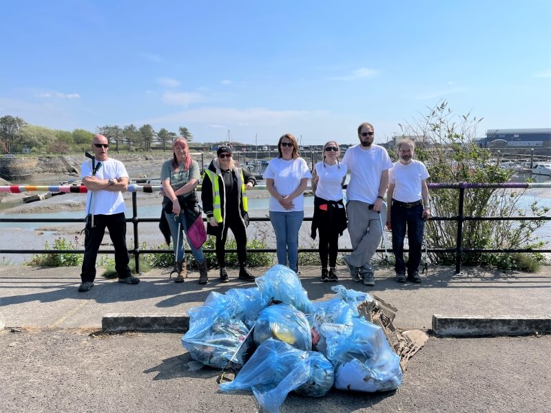 CWM team with litter pickers and a pile of rubbish they have collected