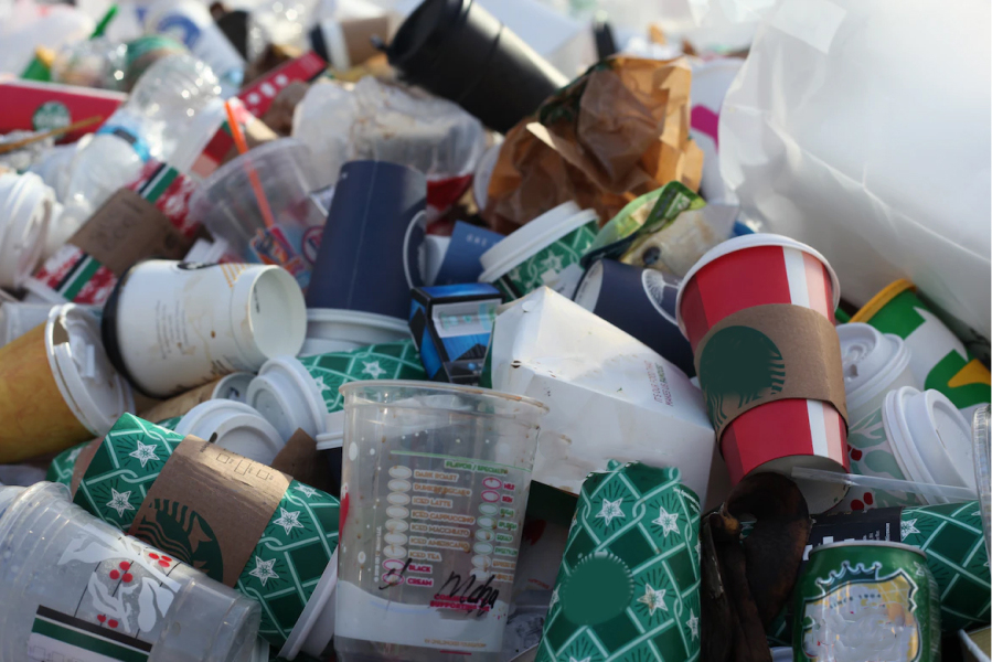 Pile of recycling hospitality materials such as paper cups and cardboard burger boxes.