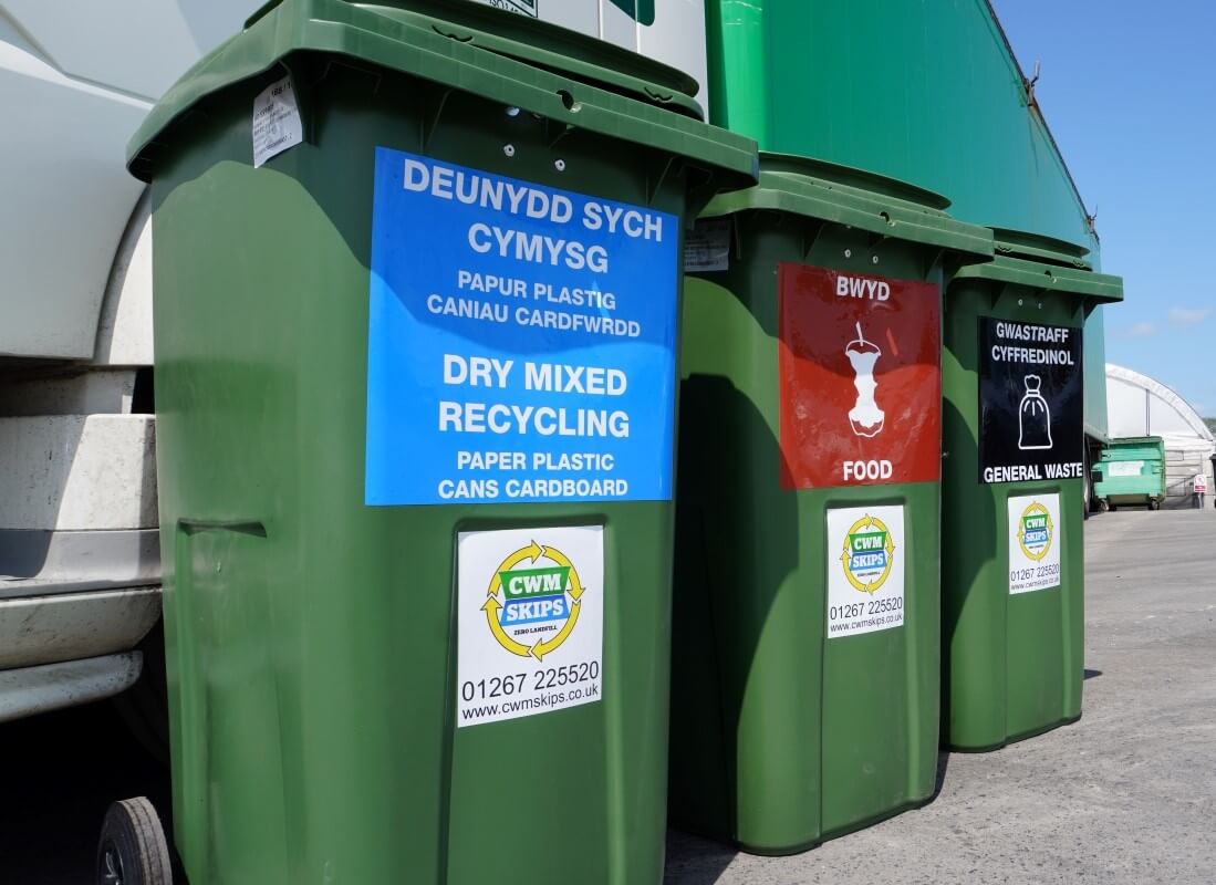 Three green wheelie bins